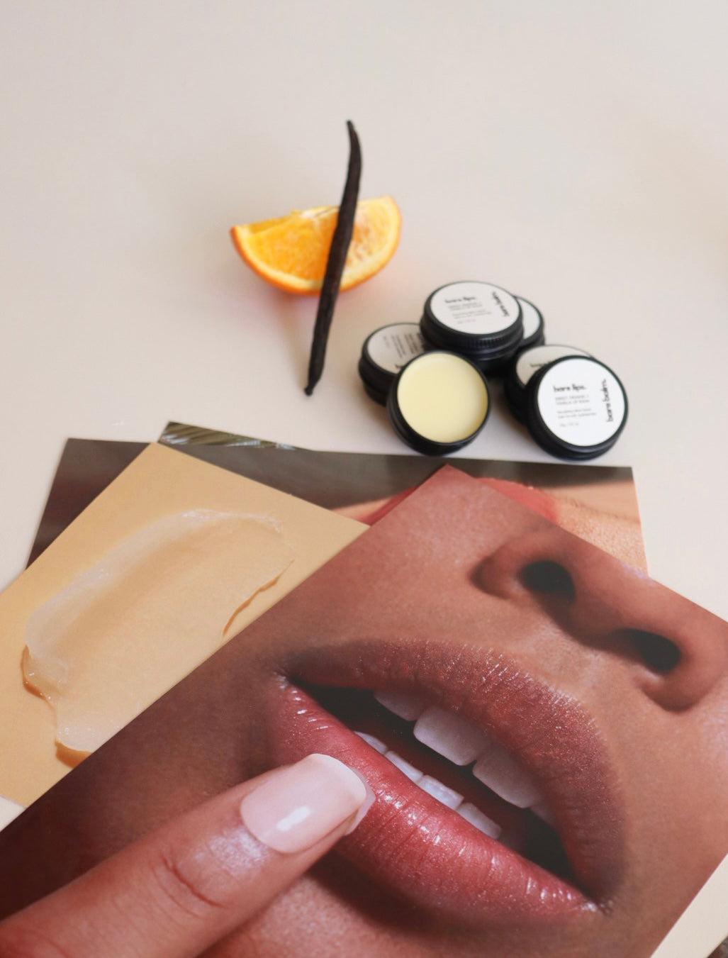 Cosmetic products and ingredients on a table with a close-up of lips.